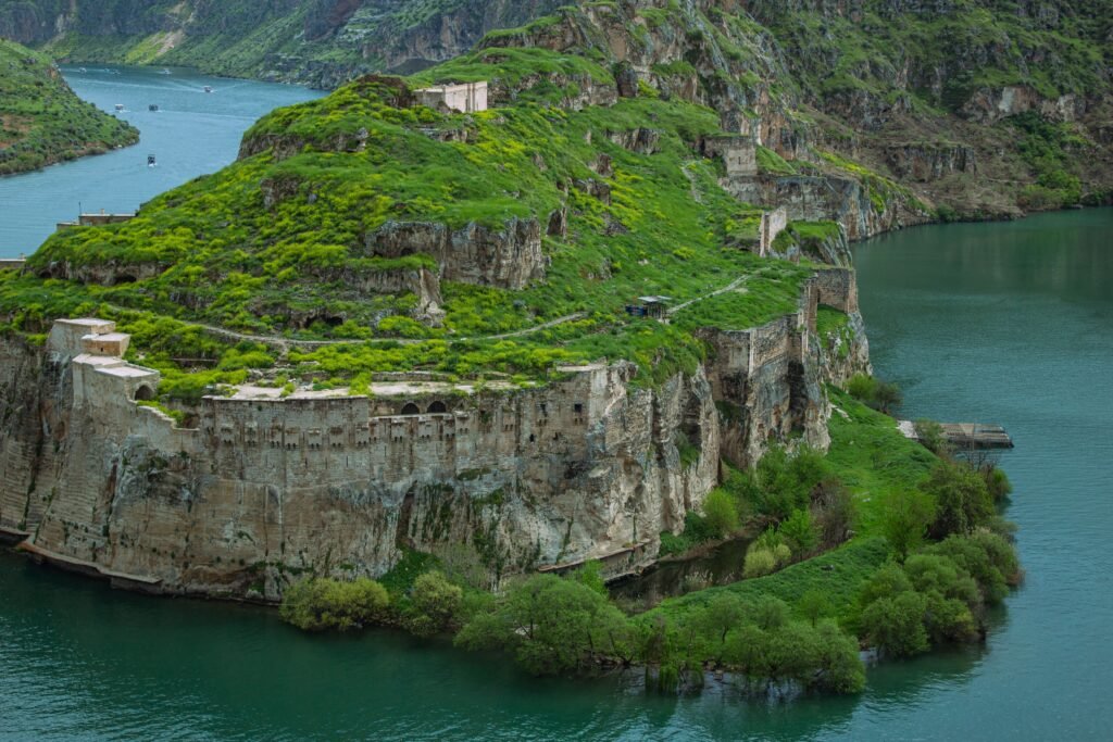 Scenic view of Rumkale Fortress with lush greenery and Euphrates River in Şanlıurfa, Türkiye.